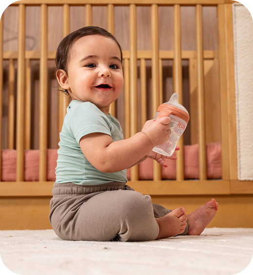 [Translate to Czech (Reborn) nuk.cz:] Baby with Learner Bottle
